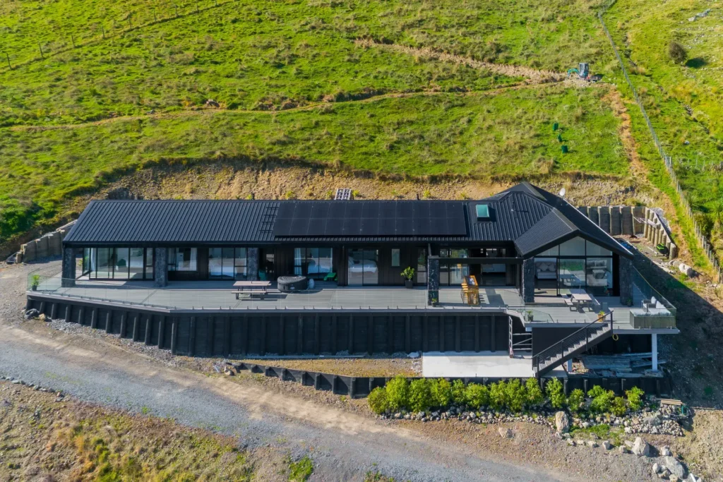 Elevated modern home on Huia Street, Waikanae, with angular rooflines and glazing over Kāpiti Island views