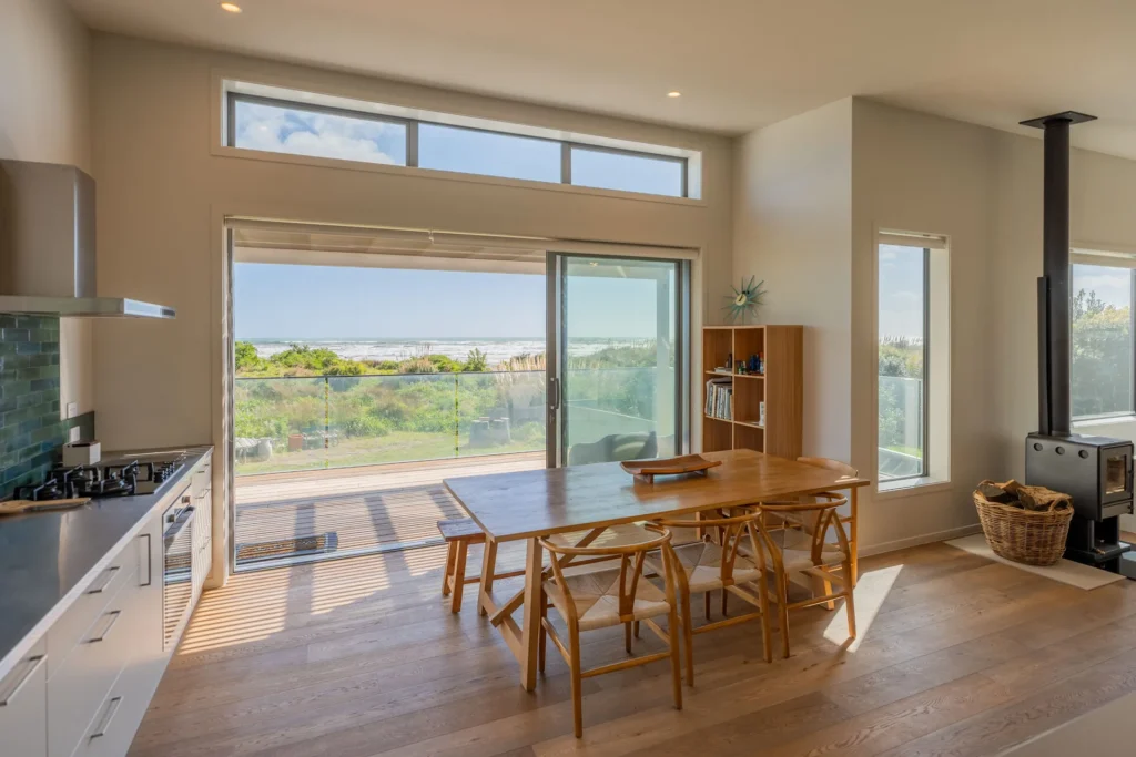 Beachfront Living Elevated - upper living and dining opening through sliding doors to the sea-view deck