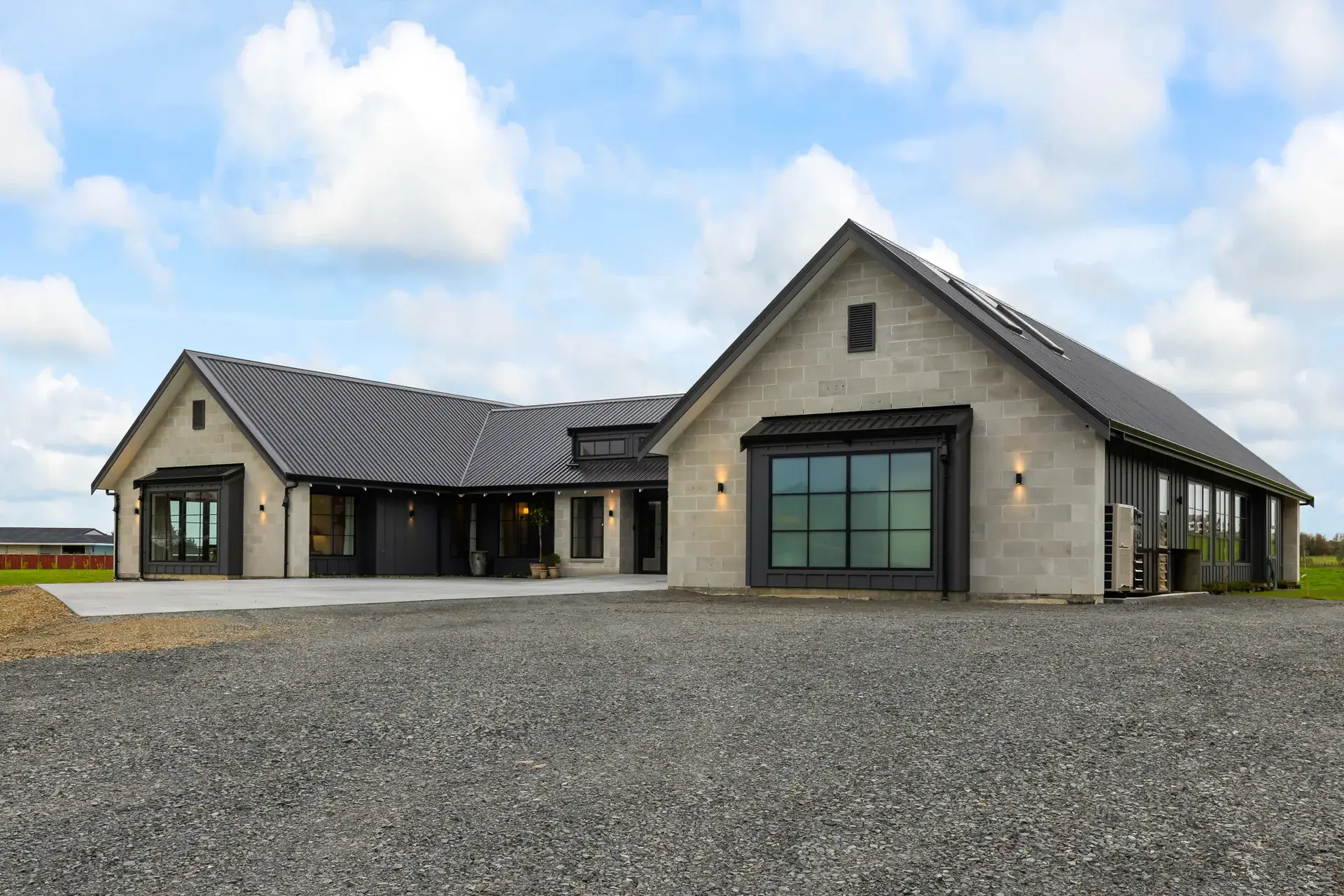 Country Estate Elegance - front elevation with schist-toned block gables, dark standing-seam roof and black-framed windows